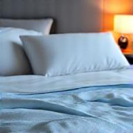 A tranquil bedroom scene with soft, inviting bedding, suggesting restful sleep and recovery.